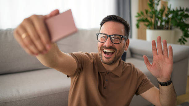 istock Handsome man using smart phone video call waving hand 1391932252