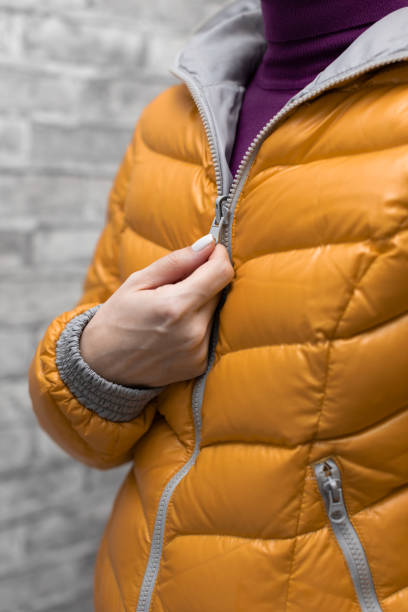 istock a woman zips up her jacket around her throat 1391933577