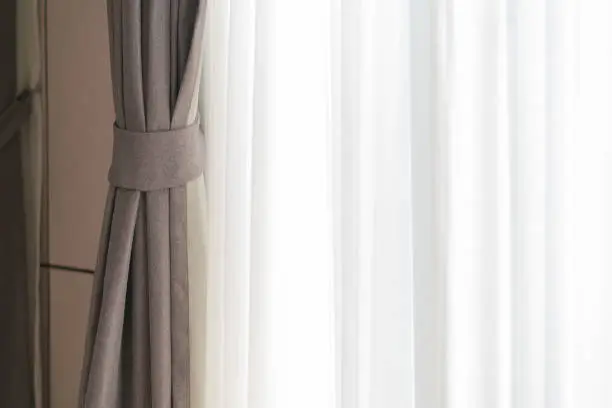 Photo of soft brown curtain with morning light from window bedroom background banner header size image