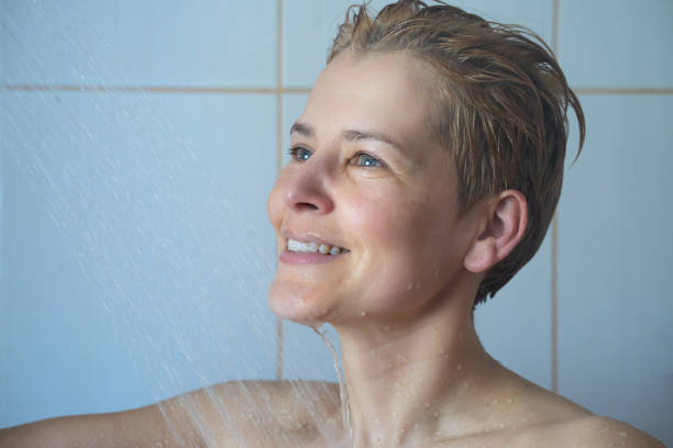 istock Happy middle aged woman taking a warm shower 1391937571