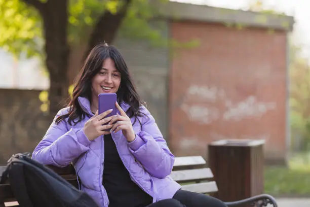 Photo of Young woman taking a selfie outdoors and smiling