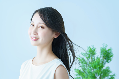 Asian young woman with fluttering hair and a smile