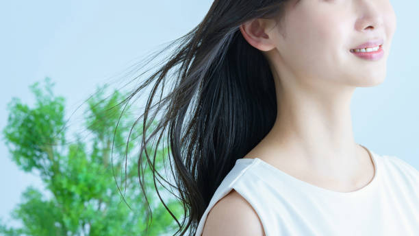 jeune femme aux cheveux qui voltigent et au sourire - beauté et soins du corps photos et images de collection