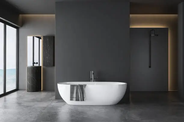 Photo of Dark grey bathroom with white bathtub and two sinks with square mirrors and shower area.