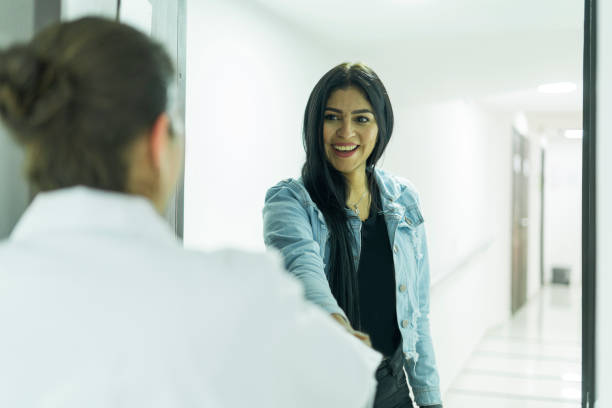 istock Doctor greets his patient after opening the office door 1391945324