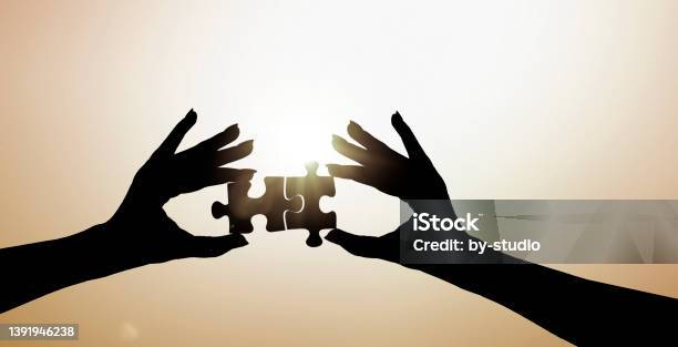 Two Hands Put Two Pieces Of The Puzzle Together Stock Photo - Download Image Now - Color Image, Finger, Germany
