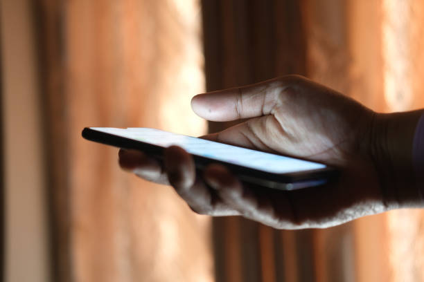 istock Close up of young man hand using smart phone at night 1391948477