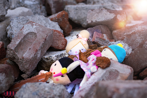 Toys on the rubble of a collapsed building