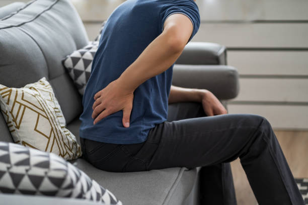 Back pain, kidney inflammation, man suffering from backache at home stock photo