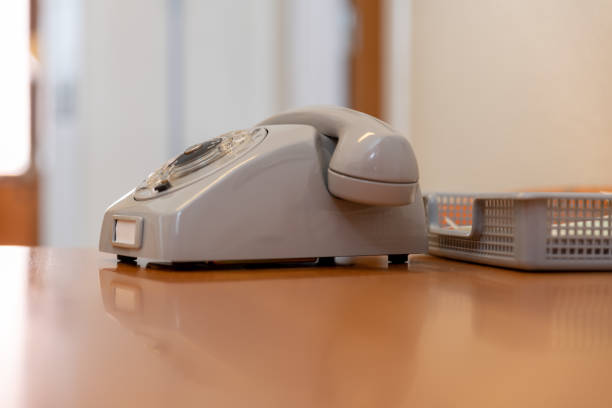 A mobile phone in home docking station, isolated on light grey