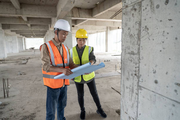 istock Two engineers were looking at drawings at an office building construction site. 1391953141