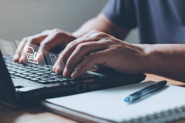 istock Businessman uses computer laptop for online editing document with the virtual screen. Online documentation database, Document Management System (DMS), Process automation to efficiently manage files. 1391954355