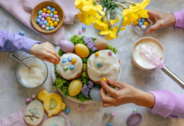 istock Grandmother and granddaughter decorating Easter cakes with chocolate eggs 1391959089