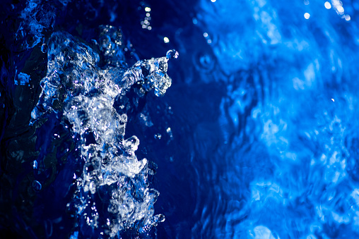 Moving water in bathtub, whirlpool water jet, blue bathtub sparkling water