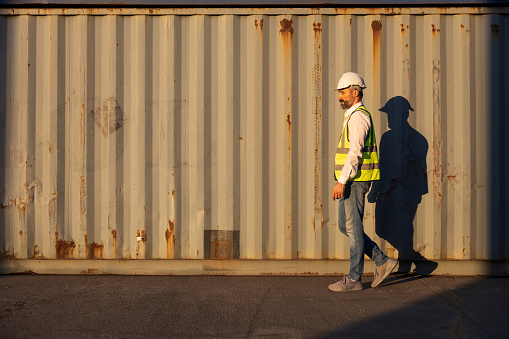 factory worker or engineer walking forward in containers warehouse storage
