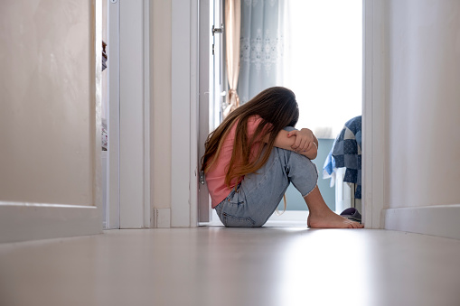 stressed teenage girl put her head on her knee