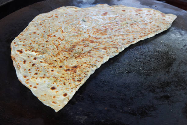 Appetizing Turkish flatbread is fried on a semicircular oven stock photo
