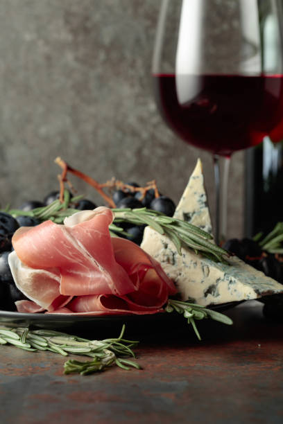 istock Red wine with grapes, rosemary, prosciutto, and blue cheese. 1391966281