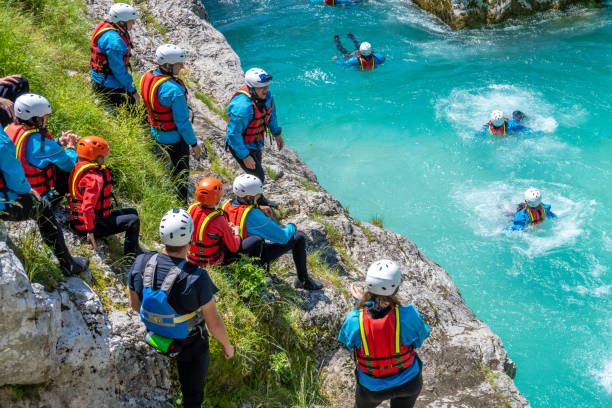 Adrenaline adventure in mountain gorge, jumping from rock to cold water Adrenaline adventure in mountain gorge. Jumping from rock to cold water. Using life jacket and helmet. Amazing turquoise clear water in Soca river, Slovenia. primorska white sport nature stock pictures, royalty-free photos & images