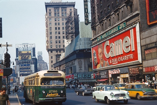New York City, NY, USA, 1965. Street scene with buildings, advertising, traffic, pedestrians and shops on times square.