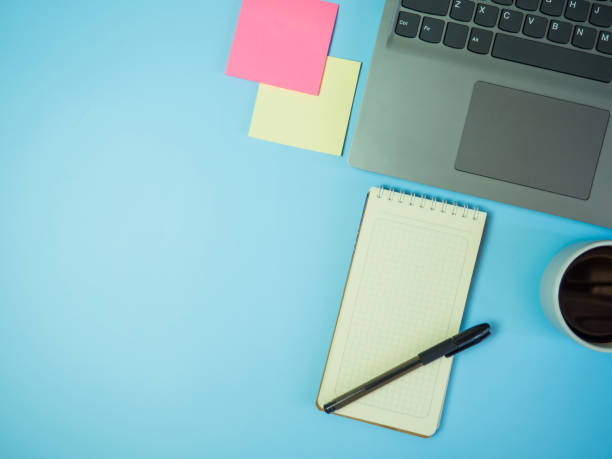 istock Business office desk concept ideas. top view with laptop, coffee and blank notepad on blue background.copy space 1391968846