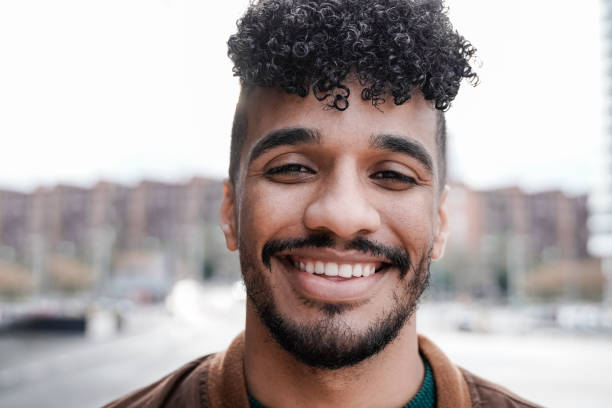 istock Latin young man smiling on camera outdoor - Focus on face 1391968983