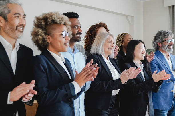 istock Multiracial and multi-generational group of people celebrating together inside bank office - Soft focus on Chinese woman clapping hands 1391969012