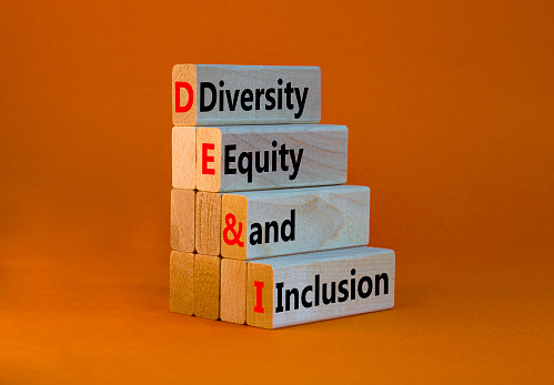 DEI, Símbolo de diversidad, equidad e inclusión. Palabras conceptuales DEI, diversidad, equidad e inclusión en bloques de madera sobre hermoso fondo naranja. Concepto de negocio, DEI, diversidad, equidad e inclusión. photo