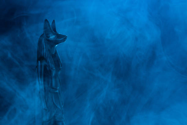 statue égyptienne du dieu de la mort anubis en pierre noire dans un brouillard bleu sur fond noir - anubis photos et images de collection