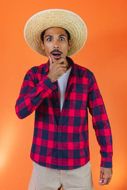 Black Man With Junina Party Outfit  Isolated on Orange Background. stock photo