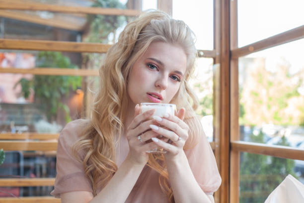 istock Lovely young woman is drinking coffee in a cafe 1391971116