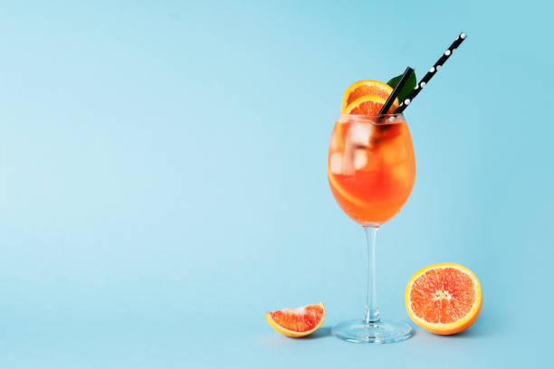 aperol spritz em vidro com fatia de laranja no fundo azul - blue transparent cold cube - fotografias e filmes do acervo