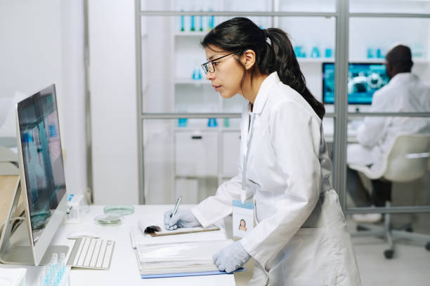 istock Side view of young serious female clinician looking at computer screen 1391972390