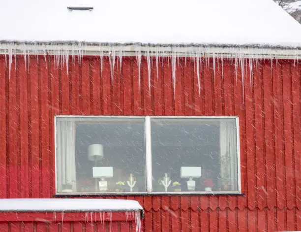 Photo of Icicles hanging from the roof of a typical nordic house in Hammerfest, the northernmost town in the world, Troms og Finnmark, Norway.