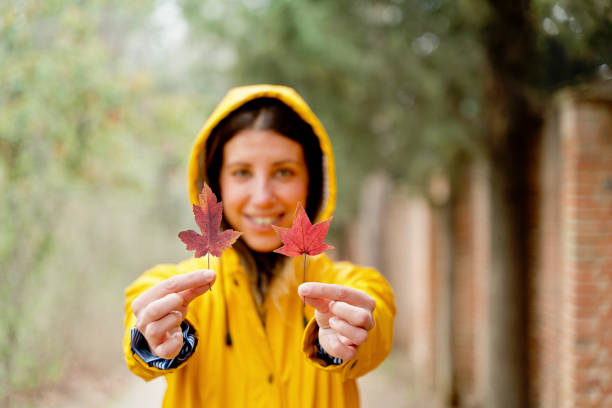 A woman carrying her adopted stray dog in her arms during autumn.