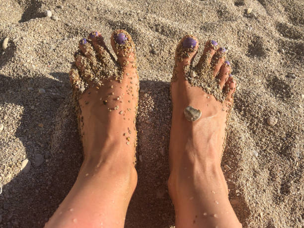 nahaufnahme der füße einer frau im sand am strand - menschlicher zeh stock-fotos und bilder