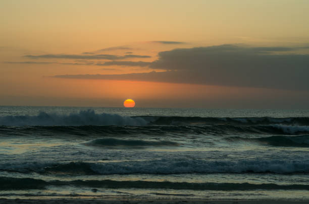 istock Sunset at the beach with beautiful sky and waves 1391974325