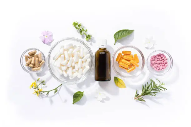 Photo of Flat lay composition of various vitamin capsules and dietary supplements isolated on white background. Vitamin complexes concept.