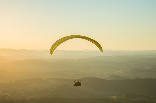 Paraglider flying solo during sunset