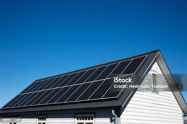 Solar Panels On Small Wood Board Domestic House Roof Sustainable Energy Concept Lot Of Copy Space On Clear Blue Sky Stock Photo - Download Image Now