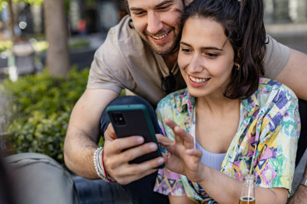 istock Man and woman relaxing outdoors and using smart phone 1391980841