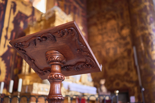 detail of a carved wooden lectern in a church altar