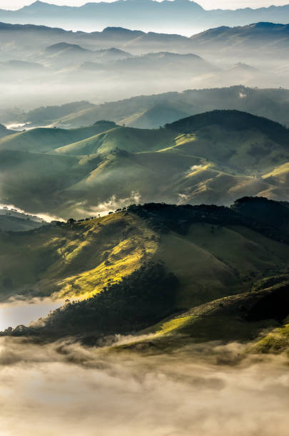 Aerial view of hilly landscape in foggy day and beautiful sunlight Aerial view of hilly landscape in foggy day and beautiful sunlight. View from Pedra Branca, Conceição das Pedras, Minas Gerais, Brazil. mantiqueira mountains stock pictures, royalty-free photos & images