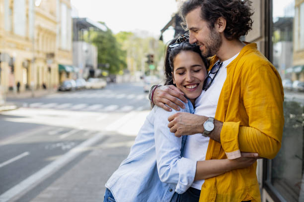 jovem casal abraçando na cidade - women heterosexual couple love men - fotografias e filmes do acervo