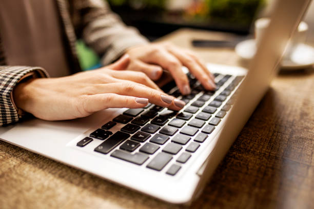 istock Unrecognizable person typing on her laptop in a cafe 1391982944