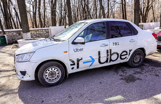 Samara, Russia - April 16, 2022: Uber taxi cab is parked on a city street in summer