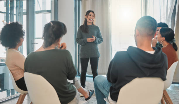 istock Shot of a young woman talking during a group therapy session 1391991652