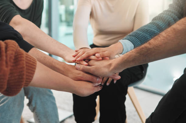 istock Shot of people stacking their hands during a group therapy session 1391991653