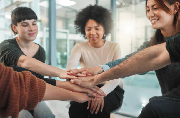istock Shot of people stacking their hands during a group therapy session 1391991656