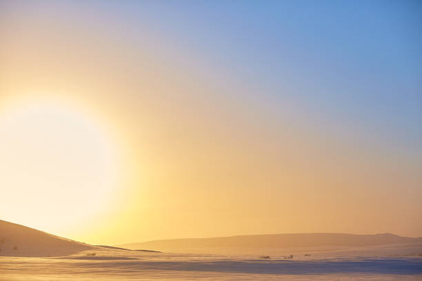 winter sunset on a background of snowy mountains stock photo